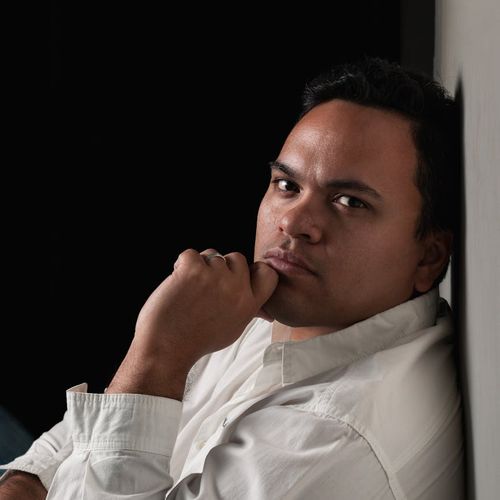 Man focusing before a workout, calm expression, dark background with cyan highlights.